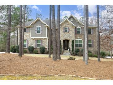 Inviting two-story home with stone and siding, surrounded by mature trees and landscaped yard at 156 Stoney Creek Way, Chapel Hill, NC 27517