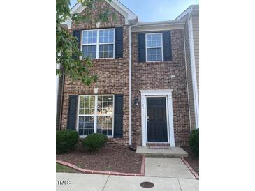 Inviting brick townhouse with manicured landscaping, classic architectural design, and a welcoming entrance at 21 Suncrest Ct, Durham, NC 27703