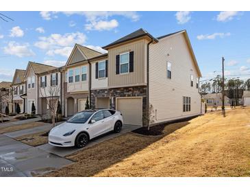 Beautiful townhome featuring stone accents, attached garage, and manicured landscaping at 3015 Cypress Lagoon Ct, Durham, NC 27703