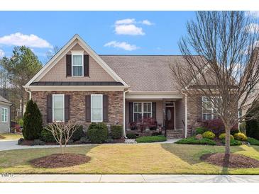 Charming single-story home boasts stone accents, manicured lawn, and inviting front porch at 4014 Peeler Ct, Rolesville, NC 27571