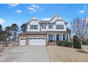 Charming two-story home featuring a stone and white siding, complemented by a well-manicured lawn at 4913 Sunset Stream Dr, Fuquay Varina, NC 27526