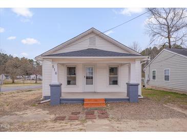 Charming home featuring a covered front porch, white siding, and a well-maintained yard at 516 Craven Road, Durham, NC 27704