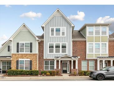 Charming townhouse with brick and siding exterior, manicured landscaping, and covered entrance at 627 Balsam Fir Dr, Cary, NC 27519