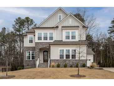 Charming two-story home featuring a stone facade, multiple windows, and a well-maintained front yard at 664 The Parks Dr, Pittsboro, NC 27312