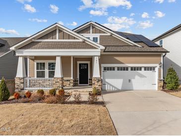 Beautiful home featuring stone accents, solar panels, and a two-car garage at 721 Sage Oak Ln, Holly Springs, NC 27540