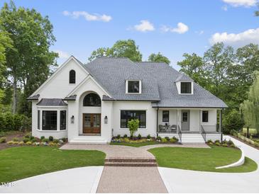 Beautiful two-story brick home with mature landscaping, a curved driveway and inviting front porch at 7217 Manor Oaks Dr, Raleigh, NC 27615
