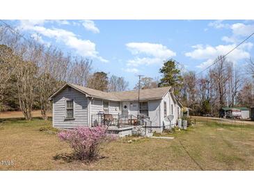 Quaint single-story home featuring a cozy front porch and a well-maintained yard at 7534 Overhills Rd, Spring Lake, NC 28390