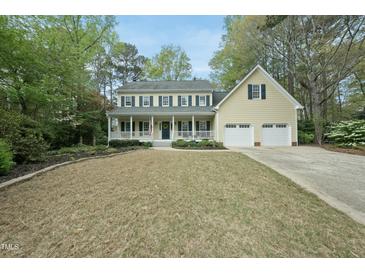 Traditional two-story home with yellow siding, blue shutters, front porch, and two car garage at 1007 Surry Dale Ct, Apex, NC 27502