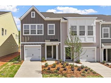Beautiful townhome with a well-manicured lawn, complemented by a gray and white facade and attached garage at 120 Central Townes Way # 292, Raleigh, NC 27603