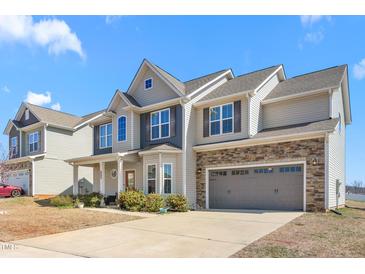 Charming two-story home with stone accents, covered porch, and attached two-car garage at 130 Campaign Dr, Mebane, NC 27302