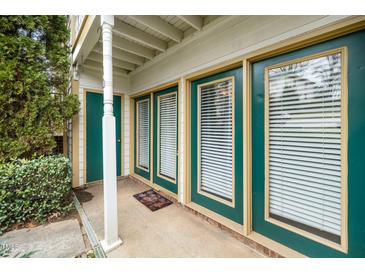 Inviting covered front entrance with a colorful welcome mat and beautiful green door and trim at 2011 Quaker Lndg # 101, Raleigh, NC 27603