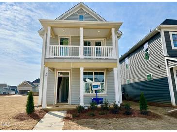 Charming two-story home featuring a covered porch, balcony, and stylish architectural details in a newly developed neighborhood at 30 Nimble Way # 171, Clayton, NC 27520
