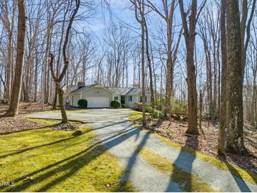 Well-maintained ranch style home with an attached garage nestled on a wooded lot with a long private driveway at 405 Lookout Pt, Rougemont, NC 27572
