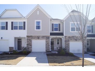 Well-maintained townhome featuring stone accents, neutral siding, and attached one car garage at 5006 Tura St, Raleigh, NC 27610