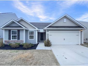 Charming single-story home with gray siding, attached garage, and manicured landscaping at 737 Little Patch St, Zebulon, NC 27597