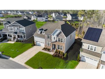 Stunning two-story home featuring a brick and stone facade, well-manicured lawn, and attached two-car garage in a desirable community at 112 Ava Ct, Holly Springs, NC 27540