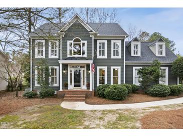 Charming two-story home with detailed trim, mature landscaping, and inviting front porch at 113 Preston Pines Dr, Cary, NC 27513