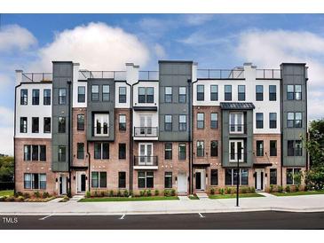 A modern townhome complex showcasing brick facades, stylish accents, and rooftop terraces under a partly cloudy sky at 1257 S Blount Street # 201, Raleigh, NC 27601