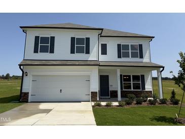 Two-story home with white siding, black shutters, a two-car garage, and manicured lawn at 131 E Victory View. Ter, Smithfield, NC 27577