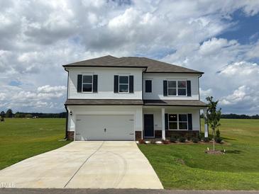 Two-story home featuring a two-car garage, neutral siding, and a well-manicured lawn at 131 E Victory View. Ter, Smithfield, NC 27577