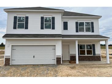 New two-story home with white siding, stone accents, dark shutters, and a two-car garage in a modern community at 131 E Victory View. Ter, Smithfield, NC 27577