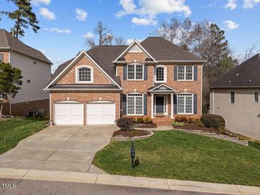 Beautiful two-story brick home with a well-manicured lawn, two-car garage and mature landscaping at 13121 Sargas St, Raleigh, NC 27614