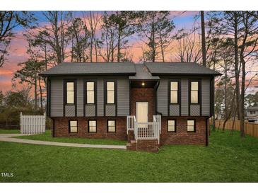 Charming two-story home with gray siding, brick foundation, and a well-manicured lawn at 1911 Stadium Dr, Durham, NC 27705