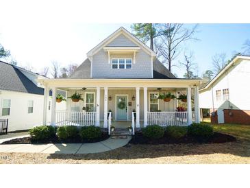 Charming home featuring a light blue door, inviting front porch and beautifully landscaped front yard at 206 Pine St, Fuquay Varina, NC 27526