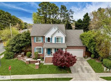 Charming two-story brick home with manicured lawn, light-grey roof, blue shutters, and attached garage at 2428 Havershire Dr, Raleigh, NC 27613