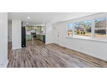 Bright living room featuring wood flooring, a front door, and a large window for natural light at 608 N 15Th St, Erwin, NC 28339