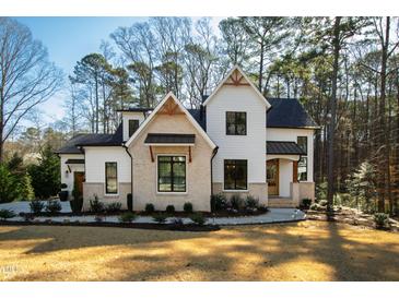 Elegant two-story home featuring a modern design with a combination of white siding and brick accents at 6816 Rainwater Rd, Raleigh, NC 27615