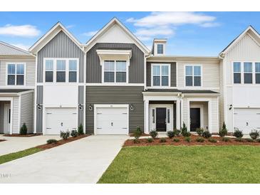 Charming townhome exterior featuring well-manicured lawn and attached one car garage at 88 Ripple Way # 314, Clayton, NC 27520