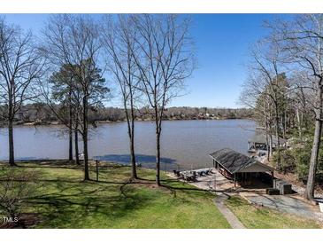 Picturesque lake view from the backyard with mature trees and a boat dock at 106 Nashua Cv, Louisburg, NC 27549