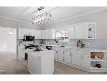 Bright kitchen with white cabinets, an island, and light blue backsplash at 125 Vance Wrenn Rd, Roxboro, NC 27573