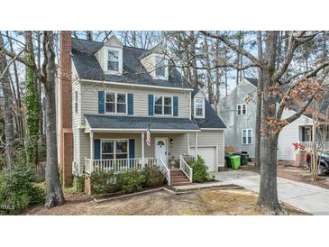 Charming two-story home with a welcoming front porch and well-manicured landscaping at 1701 Point Owoods Ct, Raleigh, NC 27604