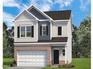 Charming two-story home features a brick base, gray siding, and attached two car garage at 184 Bruce Dr, Dunn, NC 28334
