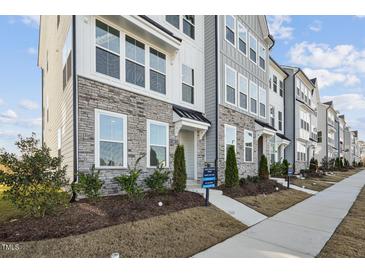 Modern townhome exteriors featuring stone accents and neat landscaping along the sidewalk at 526 Billingshurst Way, Knightdale, NC 27545