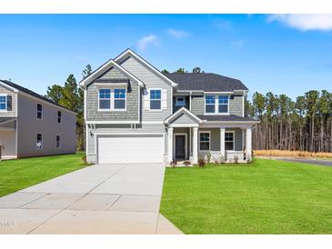 Beautiful two-story home with a well-manicured lawn and attached two-car garage at 625 Spellbrook Rd, Zebulon, NC 27597