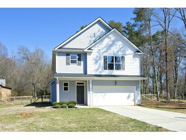 Charming two-story home featuring light blue siding, a one-car garage, and a well-manicured front yard at 704 Vance St, Mebane, NC 27302