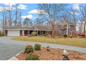 Stunning exterior view of home with a long driveway and beautiful landscaping, perfect for serene living at 95 Blueberry Rdg, Pittsboro, NC 27312