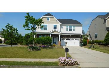 Charming two-story home with a well-maintained lawn, landscaped garden beds and a two car garage at 1001 Hope Springs Ln, Morrisville, NC 27560