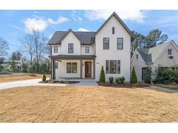 Striking two-story home with modern farmhouse design and lush front lawn and attractive landscaping at 109 W Markham Ave, Durham, NC 27701
