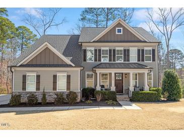 Charming home featuring a welcoming covered porch, manicured landscaping, and elegant architectural details at 1328 Mill Glen Cir, Raleigh, NC 27614