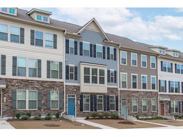 Charming townhomes featuring stone accents, multiple windows, and inviting entryways for a welcoming curb appeal at 1329 Channing Park Cir, Cary, NC 27519