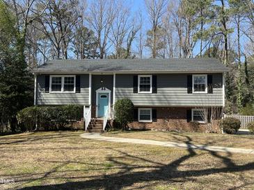 Charming two-story home with a blue door, black shutters and a well-maintained front yard at 1816 Phillips Dr, Sanford, NC 27330