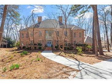 Stately brick home featuring a symmetrical design, mature trees, and well-manicured landscaping at 2602 Vintage Hill Ct, Durham, NC 27712
