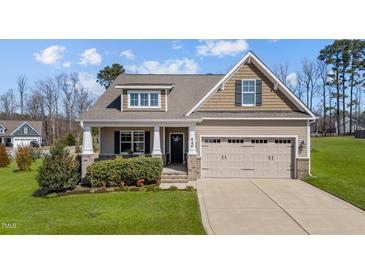 Charming single-Gathering home features a manicured lawn, inviting front porch, and two-car garage at 420 Carsons Creek Trl, Wendell, NC 27591