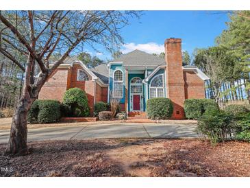 Charming two-story home featuring a red brick facade, blue accents, and a well-manicured front yard at 725 Thompson Rd, Garner, NC 27529