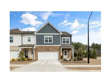 Charming two-story townhome featuring a brick facade, attached garage, and well-maintained landscaping at 1000 Pyrenees Way, Cary, NC 27519