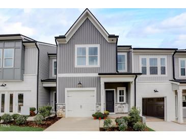 Charming two-story home with a gray siding, a garage, and beautifully landscaped front yard at 2003 Regal Dr # 90, Durham, NC 27703